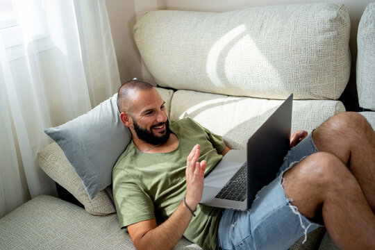 Modern Man Relaxing At Home Doing A Video Chat