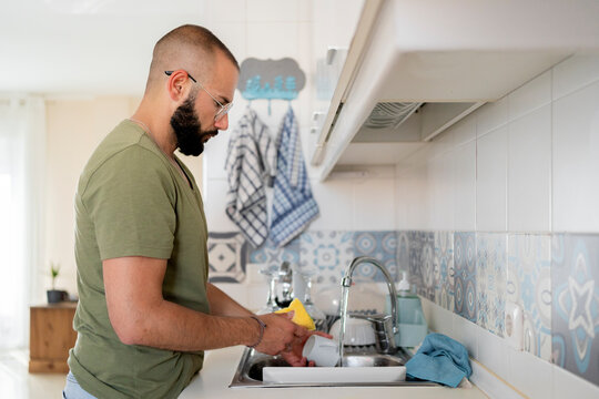Young man washing in the skin at kitchen