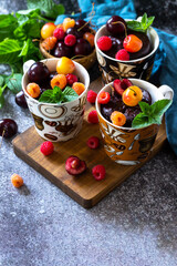 Summer breakfast or dessert. Chocolate cupcake in a mug is served with fresh summer berry raspberries and cherries. Copy space.