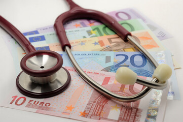 Costs and revenues in the health sector with euro banknote and stethoscope