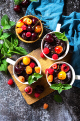 Summer breakfast or dessert. Chocolate cupcake in a mug is served with fresh summer berry raspberries and cherries. Top view flat lay background. Copy space.
