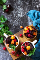 Summer breakfast or dessert. Chocolate cupcake in a mug is served with fresh summer berry raspberries and cherries. Top view flat lay background. Copy space.