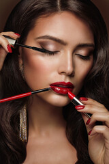 Woman applying Make up. Beauty Model Girl put on Red Lipstick. Professional Makeup Artist painting...