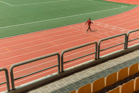 One person walks on the track of the stadium