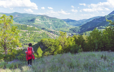 Naklejka premium Tourist Woman with Backpack on the Top of Summer Mountain with Stunning View. Summer Mountain in Bulgaria ,Bov Village ,Balkan Mountain ,Iskar Gorge