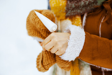Modern woman using hand cream outdoors in city park in winter