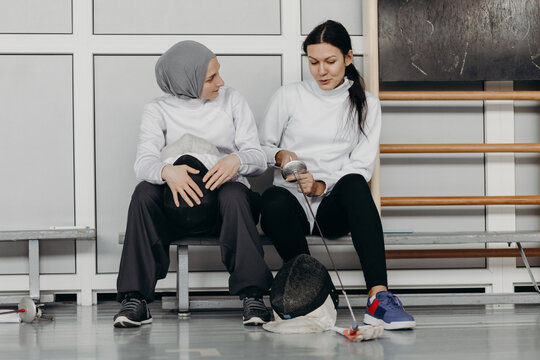Professional fencers talking to each other in gym during break