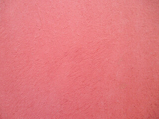 Pink wall with uneven texture. The texture is painted with a brush in different directions. Copy space. 