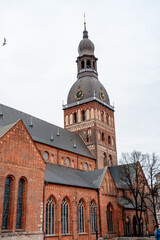 Fototapeta na wymiar Tall clock tower and bell tower of the majestic red brick catholic cathedral in old Riga (862)