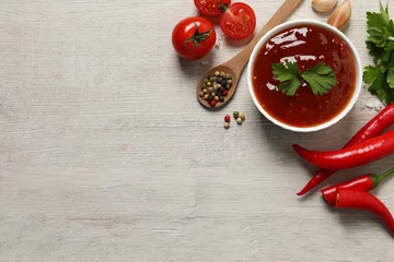 Fotobehang Spicy chili sauce and ingredients on white wooden table, flat lay. Space for text © New Africa