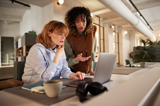 Two Businesswomen Using A Laptop At Work