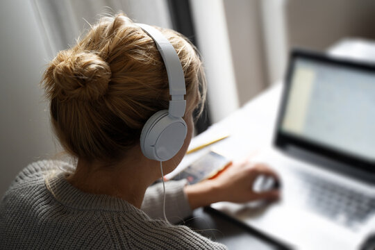 Blonde Woman With Headphones Working On Notebook Computer