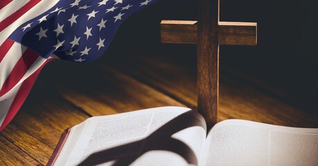 American flag over wooden cross over bible against wooden background