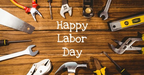 Happy labor day text and stars against multiple tools on wooden background