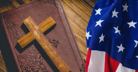 American flag over wooden cross over bible against wooden background