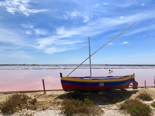 Fototapeta na wymiar fishing boat on the pink saline