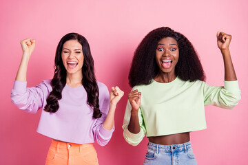 Photo of two positive ladies celebrate victory wear cropped sweatshirt isolated yellow color background