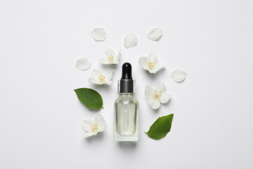 Jasmine essential and fresh flowers on white background, top view