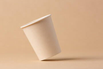 Recyclable cardboard cup balancing on a kraft cardboard background