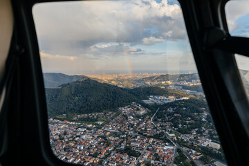 View of rainbow from inside a helicopter through the window
