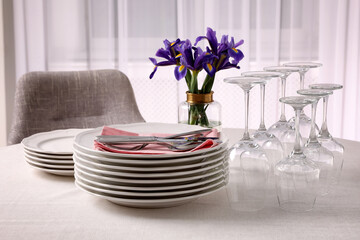 Set of clean dishware, cutlery and wine glasses on table indoors