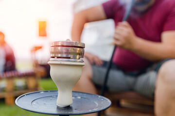 Hookah against background of group of friends. Conception is recreation on landscape campaign...