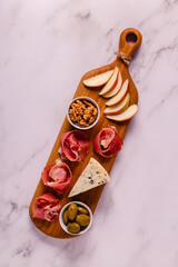 Serving board with meat and cheese snacks.