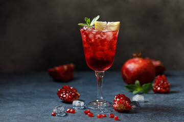 Pomegranate refreshing summer cocktail on dark background. Summer cocktail