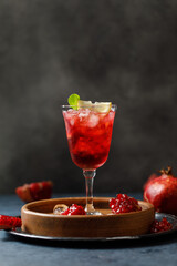 Pomegranate refreshing summer cocktail on dark background. Summer cocktail