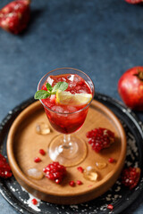 Pomegranate refreshing summer cocktail on dark background. Summer cocktail