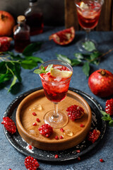 Pomegranate refreshing summer cocktail on dark background. Summer cocktail