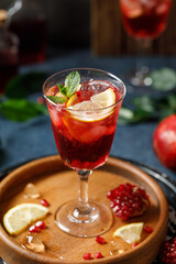 Pomegranate refreshing summer cocktail on dark background. Summer cocktail