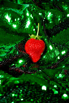 strawberry on a green sequin fabric