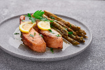 Cooked salmon fillet with asparagus in a plate close-up