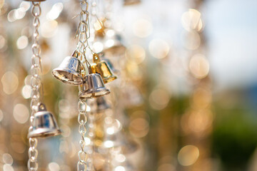 Selective focus golden bells hanging in the golden chain.