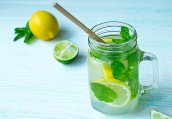 Glass mug of non-alcoholic mojito on a wooden table and ingredient on the background. Mojito...