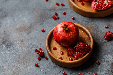 Ripe juicy pomegranate on grey background. Food background