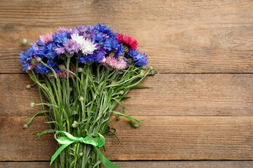 Bouquet of beautiful cornflowers on wooden table, top view. Space for text