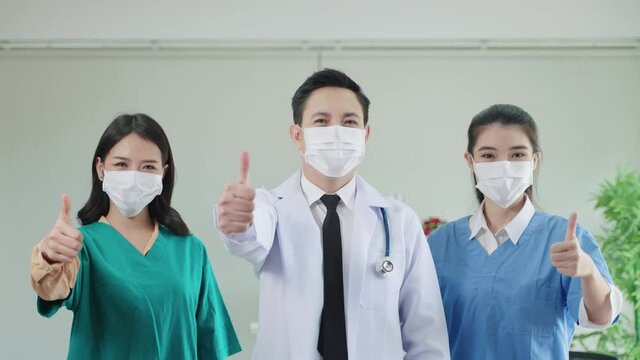 smart doctor team stood with their thumbs up confidently.
