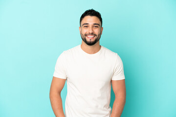 Young arab man isolated on blue background laughing