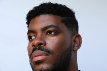 Obraz premium Close-up of handsome muscular black man looking a .side on white backgroun.,.