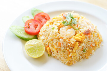 Fried rice with shrimp on the white dish on wooden table