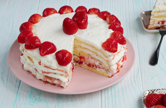 homemade strawberry cake cut. Strawberry pie decorated with fresh strawberries stands on a plate. Ice cream and strawberry cream. Cut off a piece. High quality photo