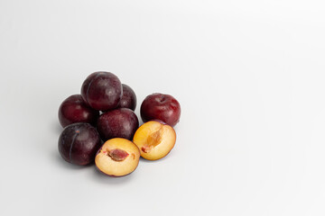 plum whole and sliced on a white background
