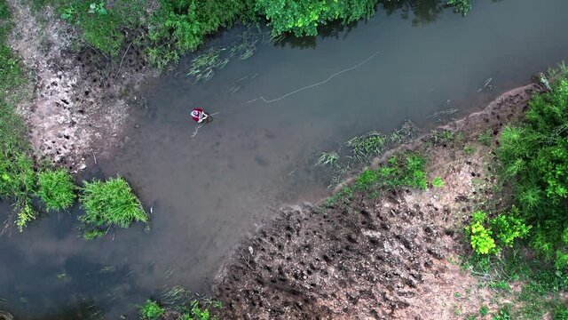 Fly fishing aerial. Angler stands in the narrow river and casts the fly with fishing rod