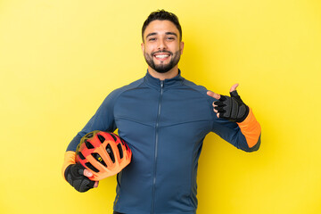 Young cyclist arab man isolated on yellow background giving a thumbs up gesture
