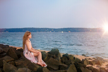 Fototapeta na wymiar Girl on beach looking at sunset
