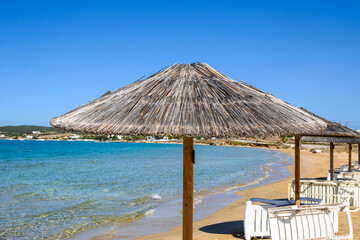 Straw umbrella at Xifara beach, a small and quiet beach located in Naoussa Bay on Paros island, Cyclades, Greece