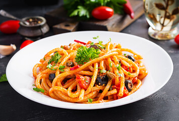 Spaghetti alla puttanesca - italian pasta dish with tomatoes, black olives, capers, anchovies and parsley.