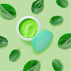 Creative beauty fashion concept photo of cosmetic recyclable bottle lotion cream with leaves on green background.